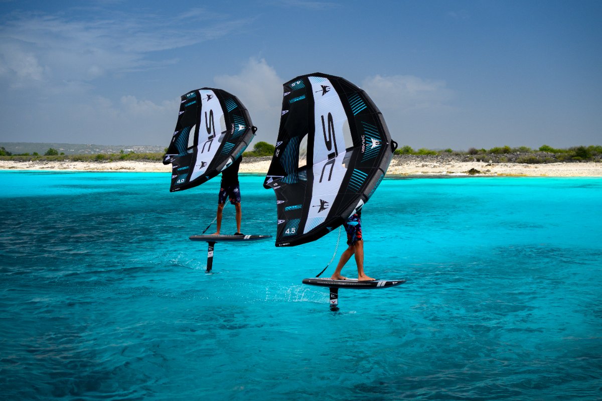 Two people with SIC Foilboards and DRAGON Wings in a clear blue ocean
