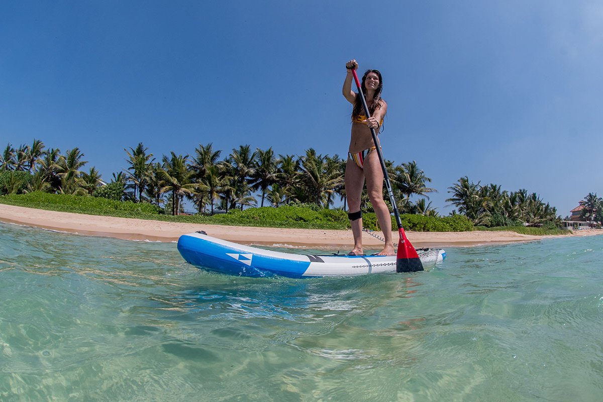 Woman in action on a SIC Maui stand up paddleboard during a tranquil session.