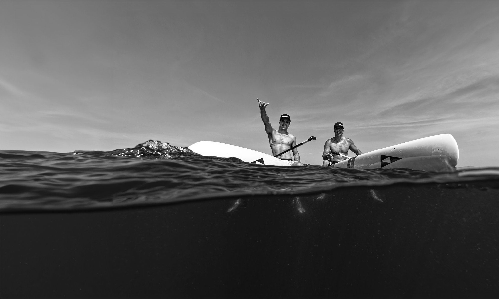Duo on a stand up paddleboarding excursion in a breathtaking ocean setting.