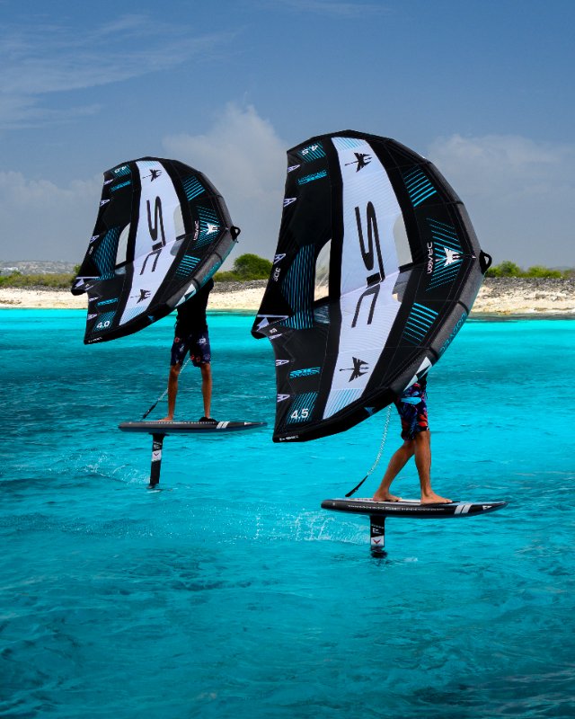 Two people with SIC Foilboards and DRAGON Wings in a clear blue ocean